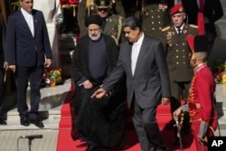 El presidente de Irán, Ebrahim Raisi, centro izquierda, camina con el presidente de Venezuela, Nicolás Maduro, cuando llegan al palacio presidencial de Miraflores en Caracas, Venezuela, el lunes 12 de junio de 2023. (Foto AP/Ariana Cubillos)