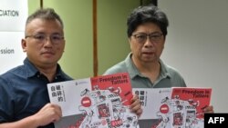 香港記者協會主席陳朗昇(左)與報告主筆楊健興手持香港新聞自由年度報告《破碎的自由》。 （2021年7月15日）