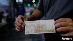 Un hombre muestra un nuevo billete de 5 bolívares, la moneda nacional venezolana, el día en que entra en vigencia su segunda reconversión monetaria en tres años, en Caracas, el 1 de octubre de 2021.