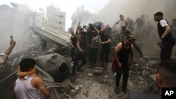 Palestinos sacan un cadáver de los escombros de un edificio después de un ataque aéreo israelí al campo de refugiados de Jebaliya, Franja de Gaza, el lunes 9 de octubre de 2023.