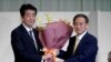 日本首相安倍晋三为在自民党总裁选举中获胜的日本官房长官菅义伟献花。（2020年9月14日）