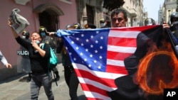 Protestuesit kundër presidentit në Peru mbartin një flamur amerikan me gërmën Q, referencë për QAnon (Lima, Peru, 9 nëntor 2020)