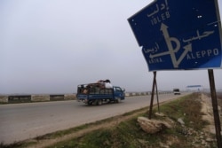 Civilians ride in a truck as they flee Maaret al-Numan, Syria, ahead of a government offensive, Monday, Dec. 23, 2019.