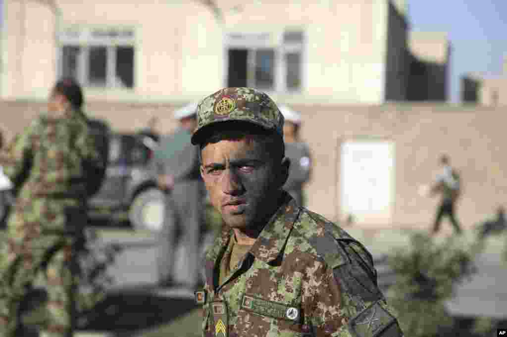 An Afghan National Army soldier who survived a roadside bomb explosion, walks by the site of the blast in Kabul, Afghanistan, Oct. 21, 2014.
