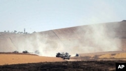 FILE - Turkish military units move inside Syria near the Turkish border town of Karkamis, Turkey, Friday, Aug. 26, 2016. 