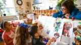 Preschool Executive Director Maria Isabel Ballivian, right, listens to her students on what characters of the TV show PAW Patrol they will vote for as their favorite character at the ACCA Child Development Center in Annandale, Va.