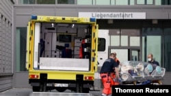 Sanitarios cargan una camilla en una ambulancia que supuestamente transportó al líder de la oposición rusa Alexei Navalny en el complejo hospitalario de Charite Mitte, donde recibirá tratamiento médico en Berlín, el 22 de agosto, 2020. 