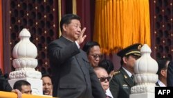 លោក​ប្រធានាធិបតី​ចិន Xi Jinping (រូប​ឆ្វេង) បក់​ដៃ នៅ​ក្នុង​ក្បួន​ព្យុះហយាត្រា​យោធា​មួយ នៅ​ក្នុង​ក្រុង​ប៉េកាំង កាលពី​ថ្ងៃទី១ ខែតុលា ឆ្នាំ២០១៩ ដើម្បី​ប្រារព្ធ​ខួប​លើក​ទី៧០​នៃ​​ការ​គ្រប់គ្រង​របស់​គណបក្ស​កុម្មុយនិស្ត។