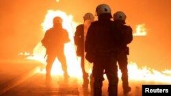 A petrol bomb explodes next to riot police as clashes erupted during an anniversary rally marking the 2008 police shooting of 15-year-old student Alexandros Grigoropoulos, in Thessaloniki, Greece, Dec. 6, 2018.