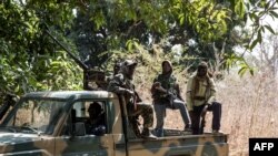 Des séparatistes appartenant au Mouvement des forces démocratiques de Casamance observent la libération de sept soldats sénégalais capturés dans un campement abandonné de Baipal, en Gambie, le 14 février 2022. 