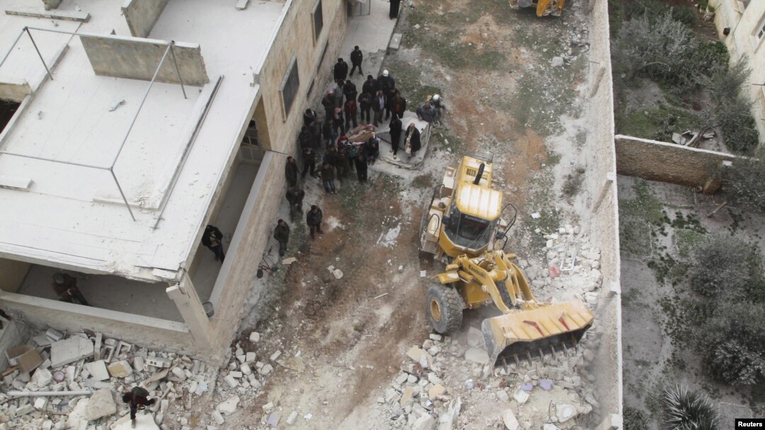 Civil defense workers remove dead bodies from under debris after an airstrike on Kafr Hamra village in the northern Aleppo countryside of Syria, Feb. 27, 2016.