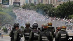 FILE - Venezuelan National Guard members watch anti-government marchers trying to make their way to the National Assembly in Caracas, Venezuela, May 3, 2017.