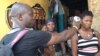 Sulaiman Watfa, an Ebola survivor, takes the temperature of resident Fatmata Bangura in the community of Moa Wharf, Sierra Leone, May 27, 2015.