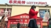 Residents walk past a Lotte Mart where additional security measures are visible in Beijing, China, March 17, 2017. Retail giant Lotte Group, South Korea's No. 5 business group, took the brunt of the backlash after agreeing to let one of its golf courses in southeastern South Korea be a site for deploying the Terminal High-Altitude Area Defense system, or THAAD. At least 55 of 99 Lotte Mart discount stores in China were shut in early March for a month each after surprise inspections found violations of fire safety standards.