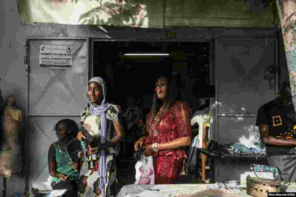 A customer picks up a skirt from her tailor in Dakar's Niary Tally neighborhood, the working class area where Dakar Fashion Week held their "Street Show" fashion show this year, June 29, 2017.