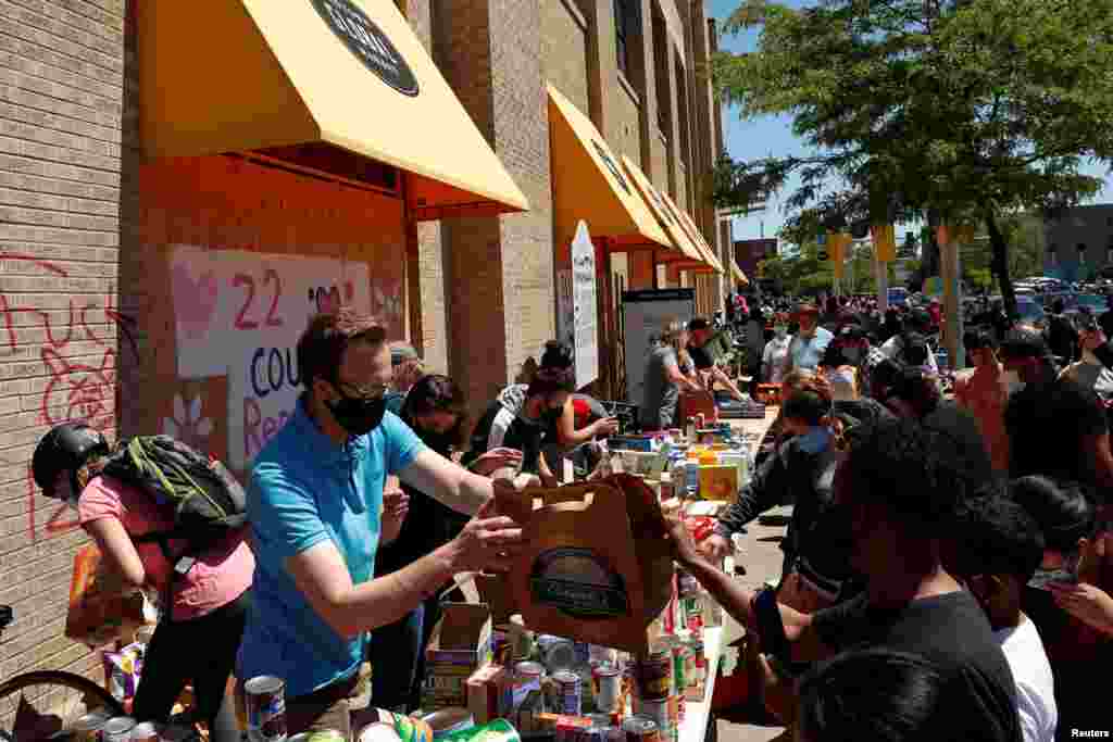 Personas en un punto de donación de alimentos cerca del área que se quemó durante las protestas contra la muerte en la custodia policial de George Floyd en Minneapolis,