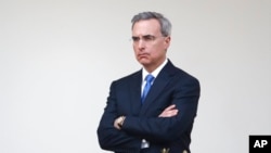 FILE - White House counsel Pat Cipollone listens as President Donald Trump speaks during a coronavirus task force briefing in the Rose Garden of the White House, March 29, 2020, in Washington. 