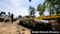 Un agent de sécurité avec un chien renifleur se tient à la prison à sécurité moyenne de Kuje, près de la capitale Abuja, Nigeria le 6 juillet 2022. REUTERS/Afolabi Sotunde
