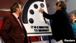 Miembros del Boletín de Científicos Atómicos, de izquierda a derecha, Lawrence Krauss, Robert Rosner y Sharon Squassoni mueven las manecillas del Reloj del Apocalipsis a dos minutos antes de la medianoche, en conferencia de prensa en Washington. Enero 25, 2018. 
