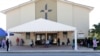 People practice social distancing as they wait at a COVID-19 testing site at Sacred Heart Church, May 5, 2020, in Lake Worth, Fla. 