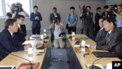 Kim Kiwoong (kiri), pemimpin delegasi tingkat pekerja Korea Selatan dan Park Chol Su (kanan) pemimpin delegasi tingkat pekerja Korea Utara dalam pertemuan di wilayah Komite Manajemen, Kawasan Industri Kaesong, Korea Utara (15/7).