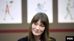 La primera dama de Francia, Carla Bruni-Sarkozy, se encuentra con varios niños en una feria del libro en París.