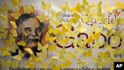 FILE - Yellow paper butterfly cutouts with messages are seen on a banner with an image of Nobel Prize-winning novelist Gabriel Garcia Marquez, on the first anniversary of his death, at a bookstore in Mexico City, Mexico, April 17, 2015.