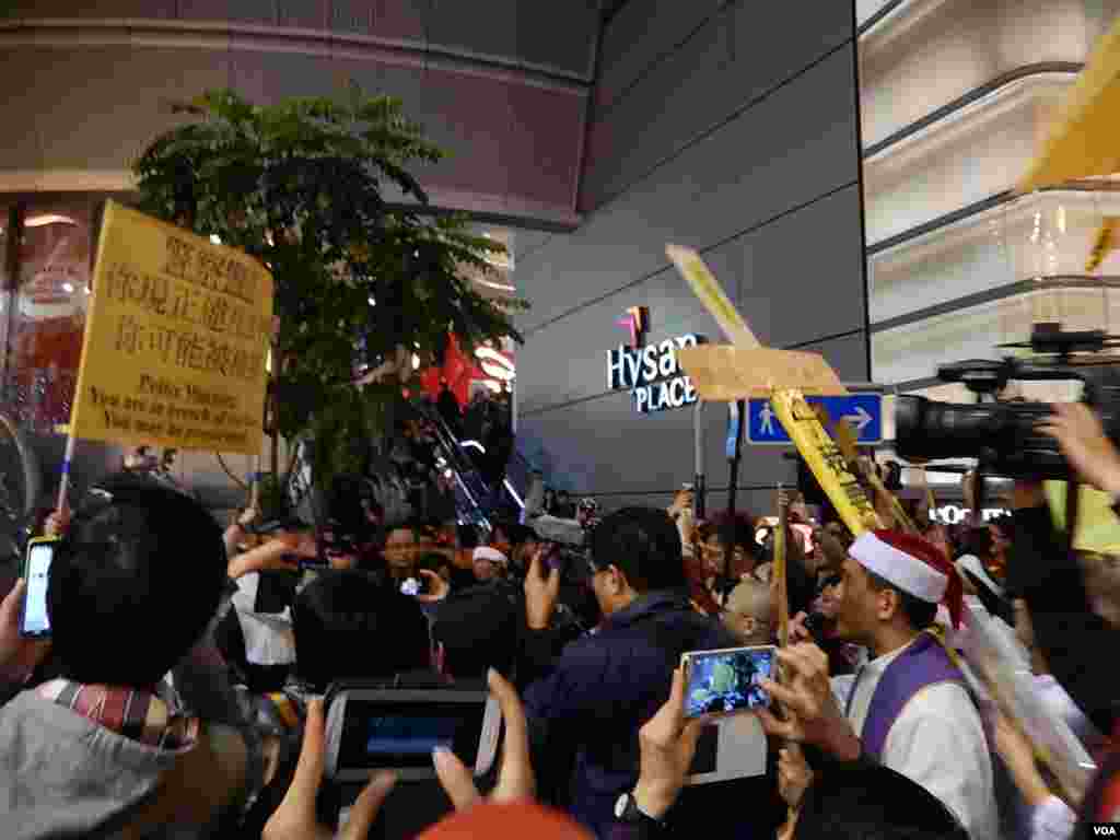 警方舉起警告標語,警告平安夜銅鑼灣報佳音的人士可能參與非法集會,主辦的宗教團體以大型十字架指向警告標語
