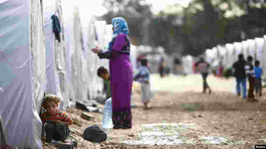 A Kurdish refugee child from the Syrian town of Kobani looks out of a tent in a camp in the southeastern town of Suruc on the Turkish-Syrian border, Oct. 19, 2014.