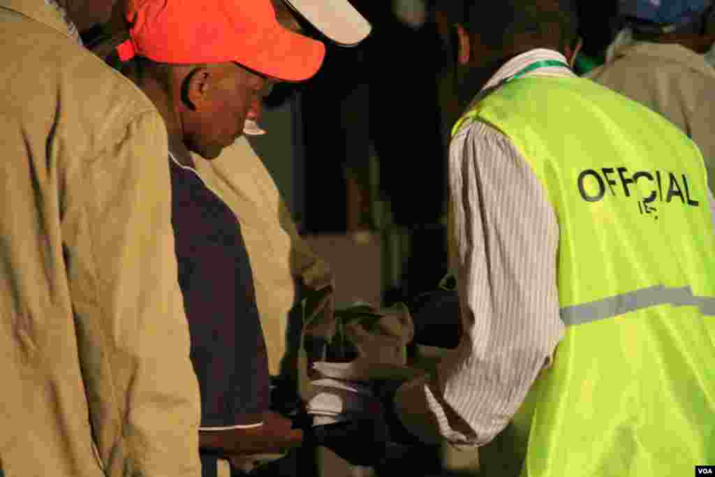 Election officials check voters’ cards at the Mutomo Primary School, where voting for the Gatundu constituency took place, March 4, 2013. (J. Craig/VOA)