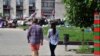 FILE - A young couple walks near a barricade outside the regional administration building in Ukraine's eastern city of Donetsk, May 14, 2014.