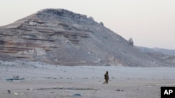 FILE - A Somali government soldier walks on the beach in Eyl, in Somalia's semiautonomous northeastern state of Puntland, March 6, 2017. Somali pirates seized a small boat and kidnapped its Indian crew members, holding them on land for nine days before they were freed by Somali security forces.