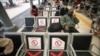 Men sit spaced apart as a social distancing effort to help curb the spread of the coronavirus in a train station waiting area, April 7, 2020, in Jakarta, Indonesia. 