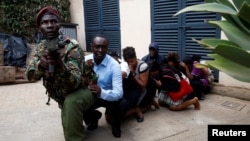Para pengunjung dievakuasi oleh anggota pasukan keamanan di lokasi tempat baku tembak dan ledakan bom di Hotel Dusit, Nairobi, Kenya, 15 Januari 2019.
