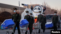 中國武警士兵在北京的冬奧會吉祥物前走過。 （2022年1月15日）