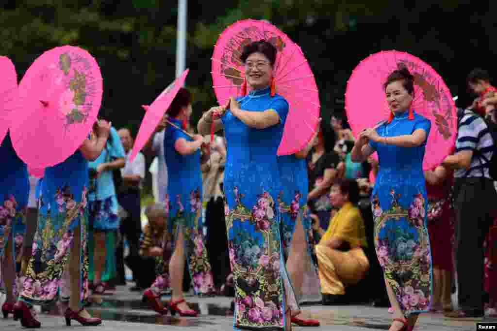 Des femmes en cheongsam en spectacle lors de la Journée internationale des droits des femmes, à Qionghai, en Chine, le 8 mars 2018.