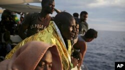 Les migrants regardent depuis le pont du bateau de l'ONG espagnole ProActiva Open Arms en attendant d'atteindre la côte italienne un jour après avoir été secourus au large de la côte libyenne, le 7 septembre 2017.