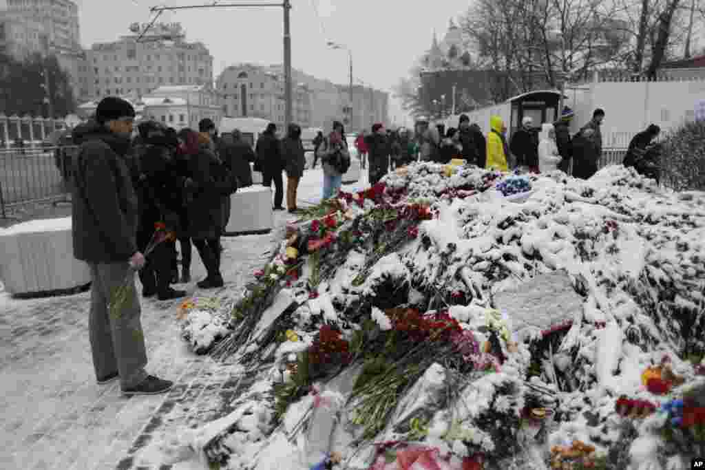 Warga menaruh bunga di depan Kedutaan besar Perancis di Moskow, Rusia (15/11), untuk para korban serangan maut di Paris. (AP/Ivan Sekretarev)