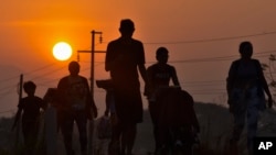 ARCHIVO: Migrantes caminan al amanecer por la carretera que atraviesa Arriaga, estado de Chiapas en el sur de México, el lunes 8 de enero de 2024, durante su viaje hacia el norte hacia la frontera con Estados Unidos.
