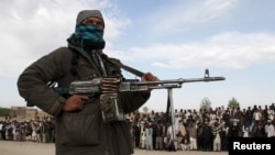 FILE - A member of the Taliban and other people stand at the site of a public execution in Ghazni province, Afghanistan, April 18, 2015. A convicted murdered is scheduled to be executed on Nov. 13, 2024, in Gardez, in the country's Paktia province. 