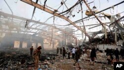 People inspect the aftermath of a Saudi-led coalition airstrike on a funeral in Sana'a, Yemen, Oct. 8, 2016. The coalition on Saturday said its warplanes bombed the wrong target.