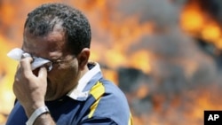 A protester wipes his eyes after being affected by tear gas in front of the Interior Ministry in Cairo