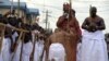Un collaborateur du palais s’agenouille devant le 40ème monarque du royaume Bénin, Oba Ewuare II, nouvellement couronné sur un pont en bois au cours d'un rite d'intronisation à Bénin City au Nigeria.