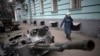 Seorang perempuan berjalan di dekat tank Rusia yang hancur dipajang di sebuah jalan di Kyiv tengah, Ukraina, Rabu, 25 Januari 2023. (Foto: AP/Daniel Cole)