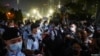 La gente mira a los oficiales de policía que hacen guardia en el Parque Victoria en el 32 aniversario de la represión de los manifestantes a favor de la democracia en la Plaza de Tiananmen de Beijing en 1989, en Hong Kong, el 4 de junio de 2021.