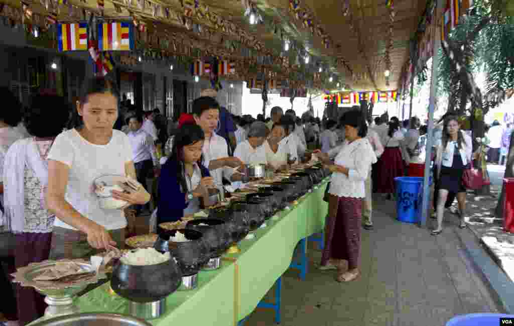 ប្រជាពលរដ្ឋដាក់ចង្ហាន់និងបច្ច័យជាប្រាក់នៅក្នុងបាត្រនៅវត្តឧណ្ណាឡោម ដែលនេះជាផ្នែកមួយនៃពិធីបុណ្យចូលឆ្នាំខ្មែរ។
