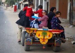 Palestinians ride on a donkey-drawn cart as they flee their homes during Israeli air and artillery strikes, in the northern Gaza Strip, May 14, 2021.