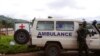 Un soldat Cameroun, à droite, se tient à côté d'une ambulance utilisée pour transporter les victimes du déraillement d'un train vendredi à Eseka, Cameroun, 22 octobre 2016. 
