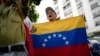 Una mujer sostiene una bandera durante una protesta contra la reelección del presidente Nicolás Maduro en Caracas, Venezuela, el sábado 28 de septiembre de 2024. (Foto AP/Ariana Cubillos)