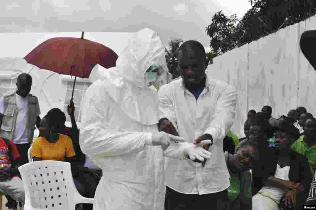 Seorang relawan medis berlatih menggunakan pakaian yang dilengkapi dengan alat pengamanan pribadi (PPE) di pusat layanan medis untuk penanggulangan Ebola yang baru dibangun di Monrovia, Liberia (21/9).